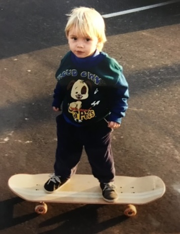 A young Haden standing on a skateboard.